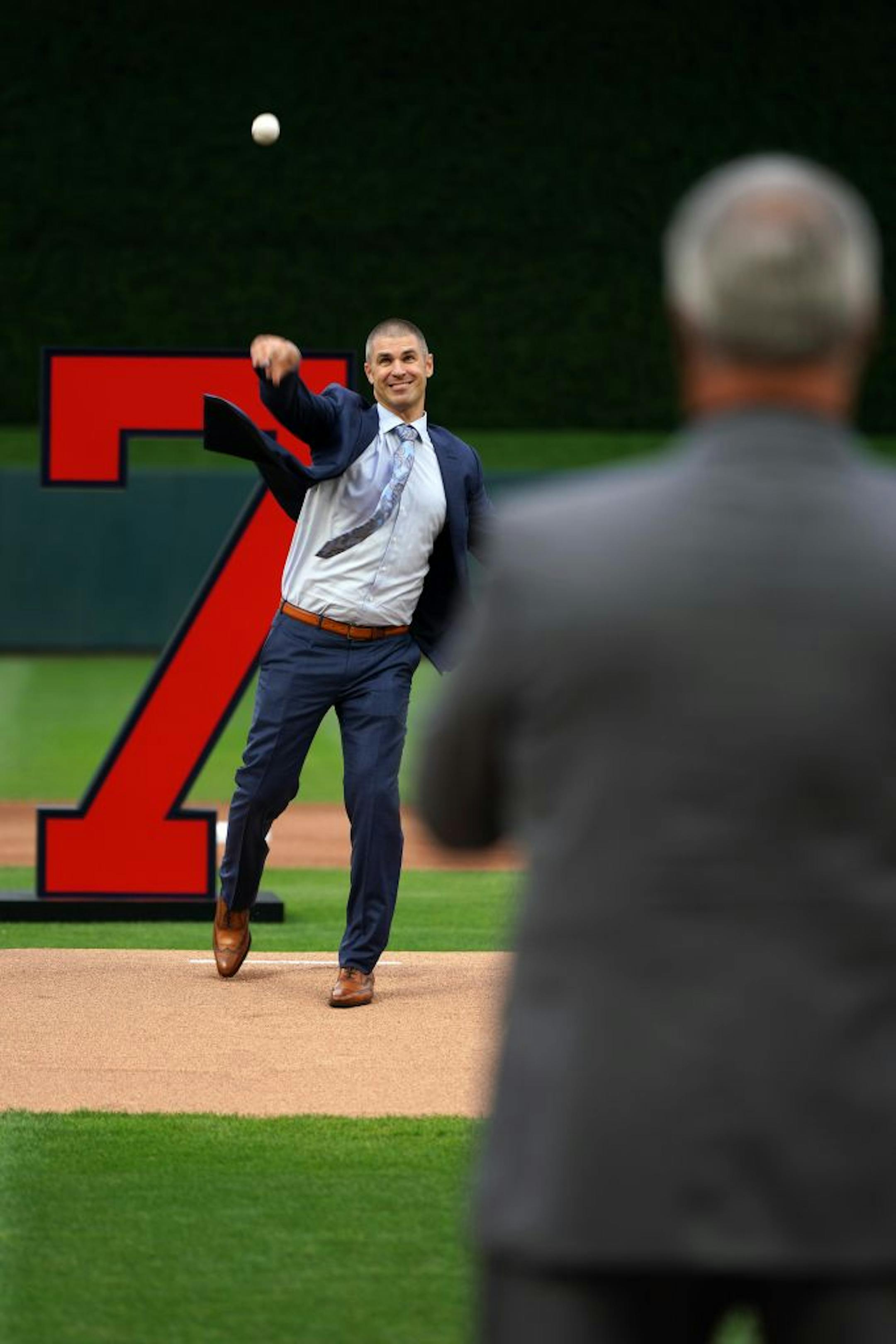 Former Minnesota Twins star Joe Mauer's threw a ceremonial first pitch to his dad Jake during a pregame ceremony to retire his number 7 Saturday.