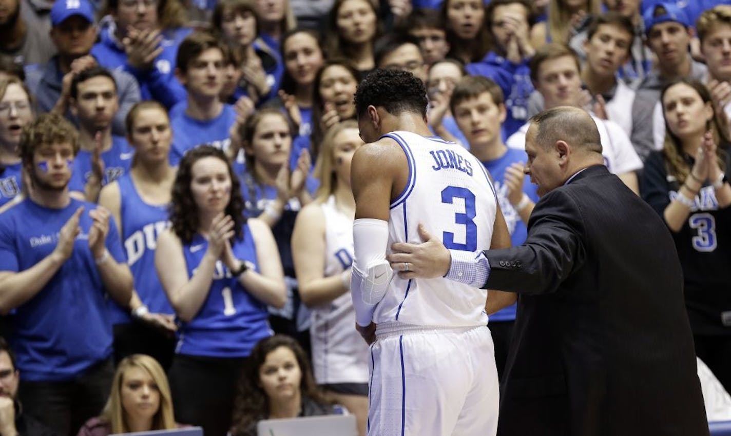 Duke's Tre Jones (3) is escorted from the court following an injury during the first half of an NCAA college basketball game against Syracuse in Durham, N.C., Monday, Jan. 14, 2019. No. 1-for-now Duke will have to figure out how to play without perhaps its most irreplaceable player now that point guard Tre Jones is out indefinitely with a shoulder injury.