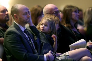 Brian Muller received comfort from his daughter EmmyLu as he bid farewell to his wife Amie Dahl Muller, 36, during her funeral services at Crossroads 