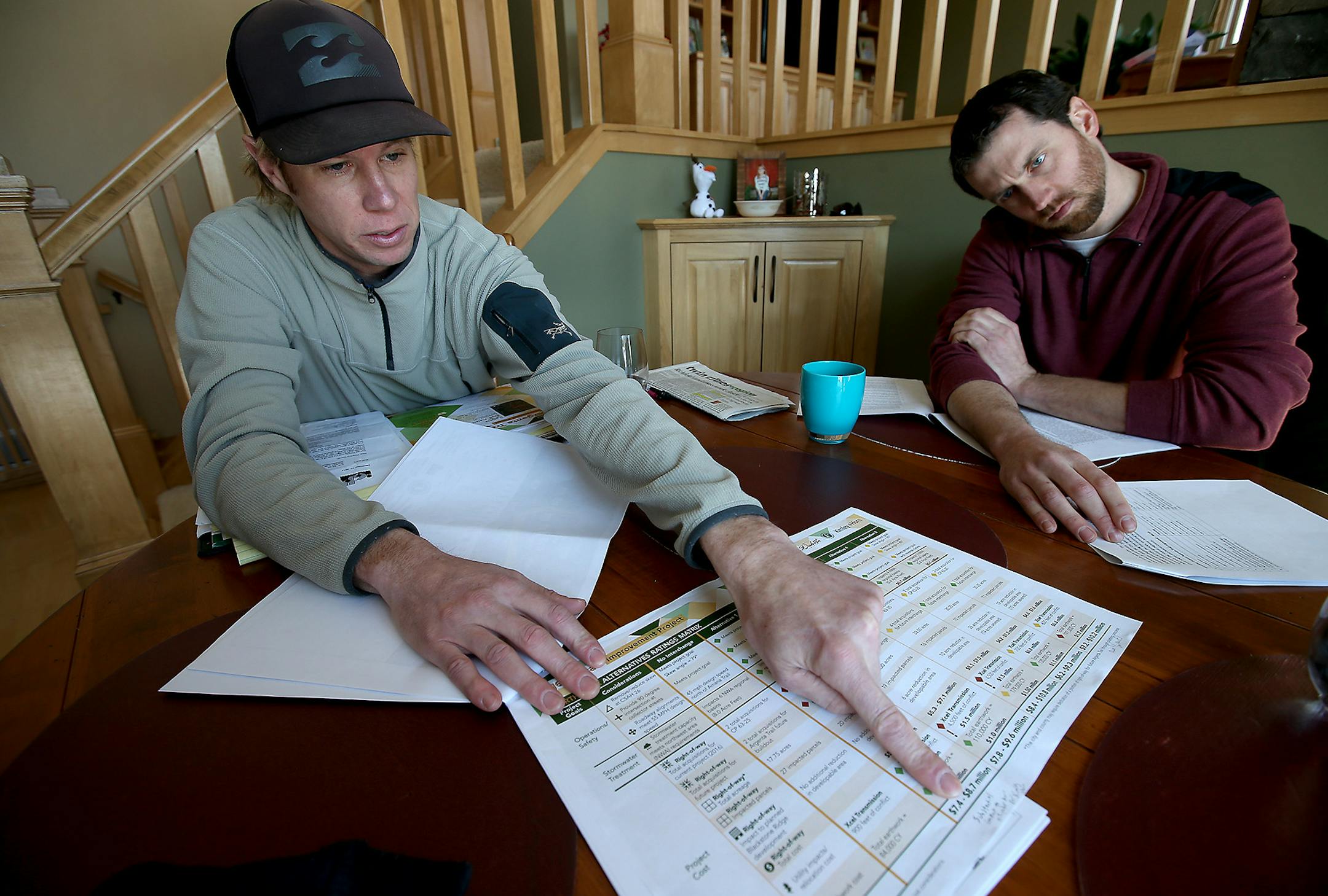 Chad Hageman, left, and neighbor Kyle Van, went over part of a proposal that is threatening a road realignment project intended to serve a new housing development, at Hageman's home, Thursday, February 5, 2015 in Inver Grove Heights, MN. The realignment would require the city to acquire about a dozen houses through eminent domain, knocking them down to make space for the road. ] (ELIZABETH FLORES/STAR TRIBUNE) ELIZABETH FLORES • eflores@startribune.com