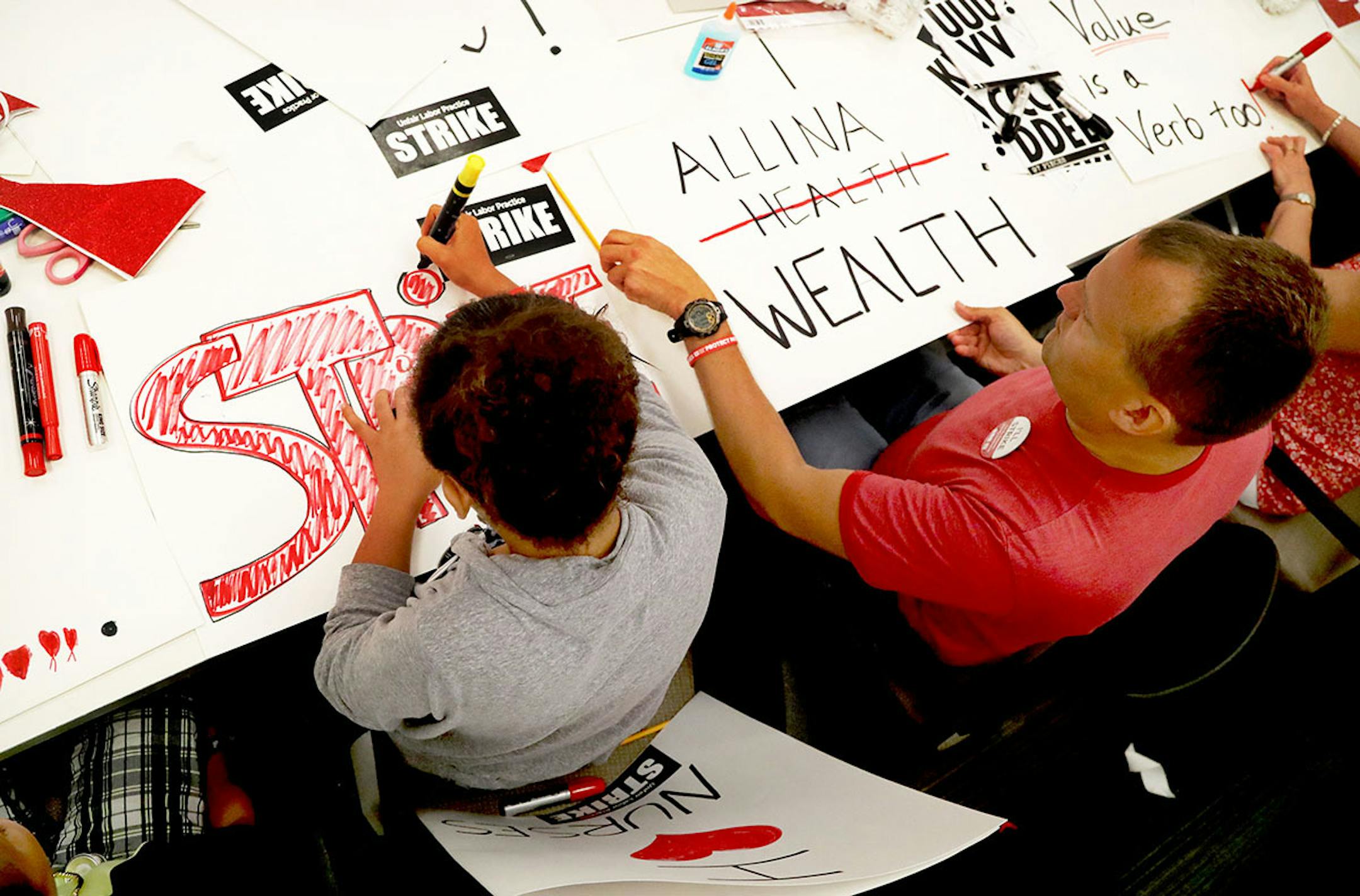 Anaya Mathis, 10, left, of St. Paul, helped her uncle Michael Ciampi, who is an RN at United Hospital in St. Paul as they joined MNA nurses, Minnesota Nurses Association employees and family members at the MNA headquarters to make posters for picketing Saturday, June 18, 2016, should a strike happen Sunday at five Twin Cities Allina Health facilities.