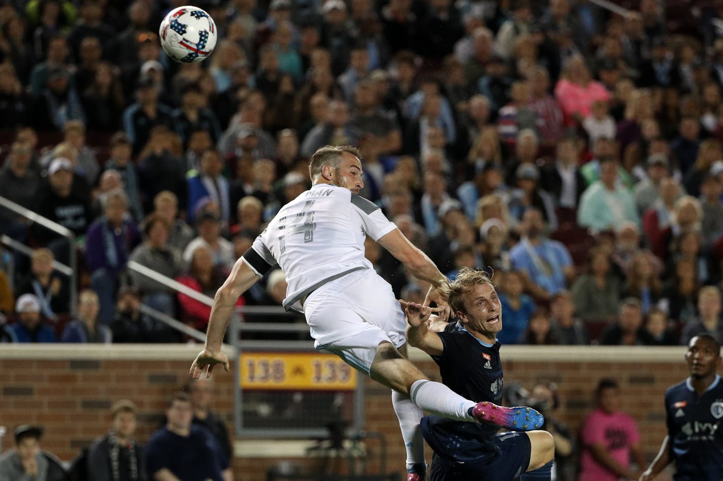 Minnesota United defender Brent Kallman (14) and Sporting Kansas City defender Seth Sinovic (15) rise up for a loose ball in the first half