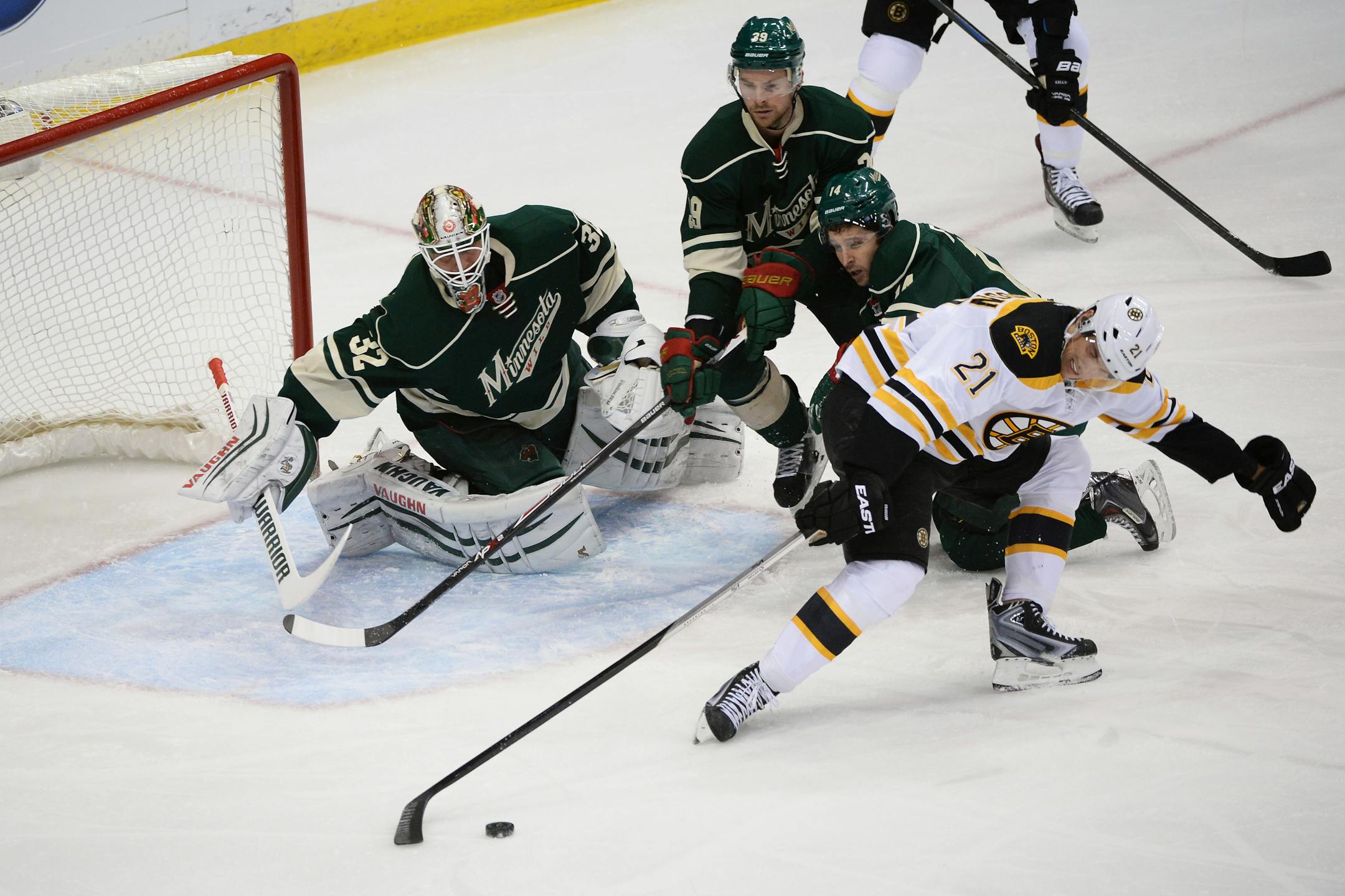 Boston Bruins left wing Loui Eriksson (21) tries to control the puck for a shot as Minnesota Wild goalie Niklas Backstrom (32) defends during the first period.