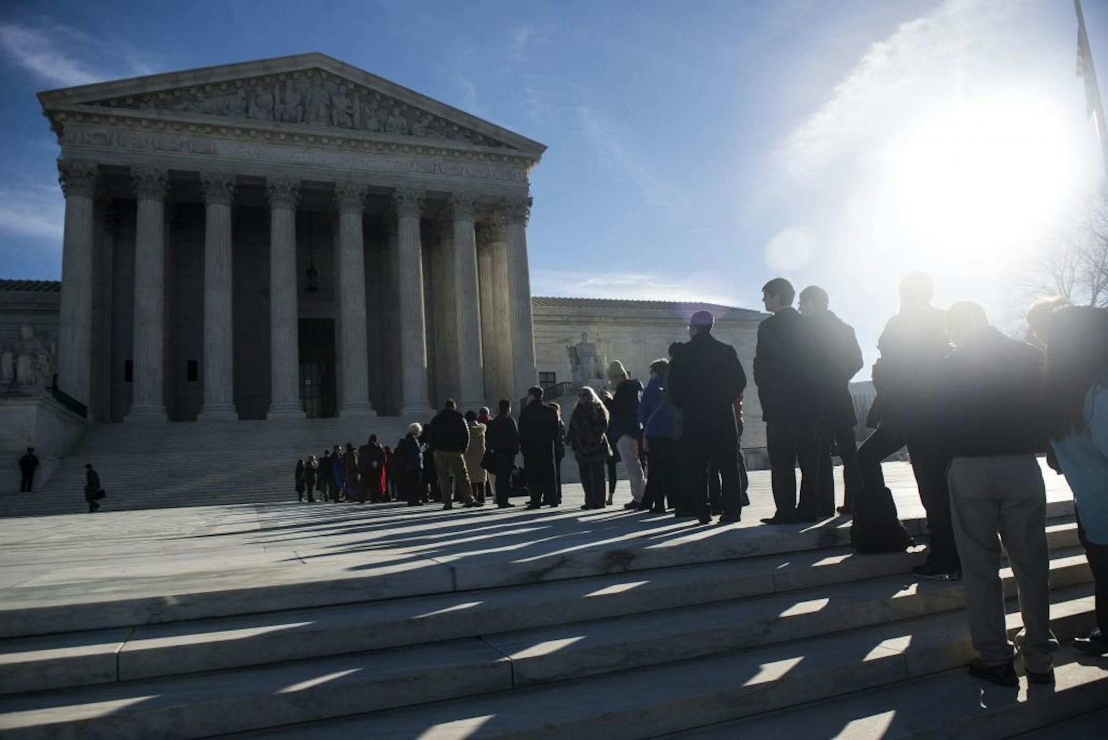 People wait in line to enter the U.S. Supreme Court on the first day of January sessions in Washington, Jan. 13, 2014.