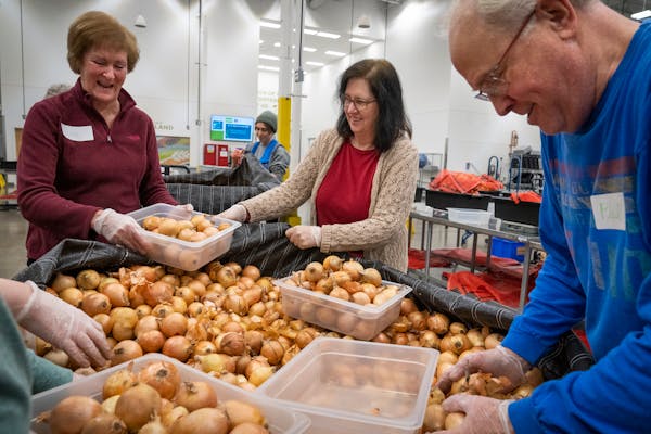 Volunteers Sue Weber, from left, Tracy Rahmig and Phil Soucheray packaged onions at Second Harvest Heartland in Brooklyn Park on Thursday.