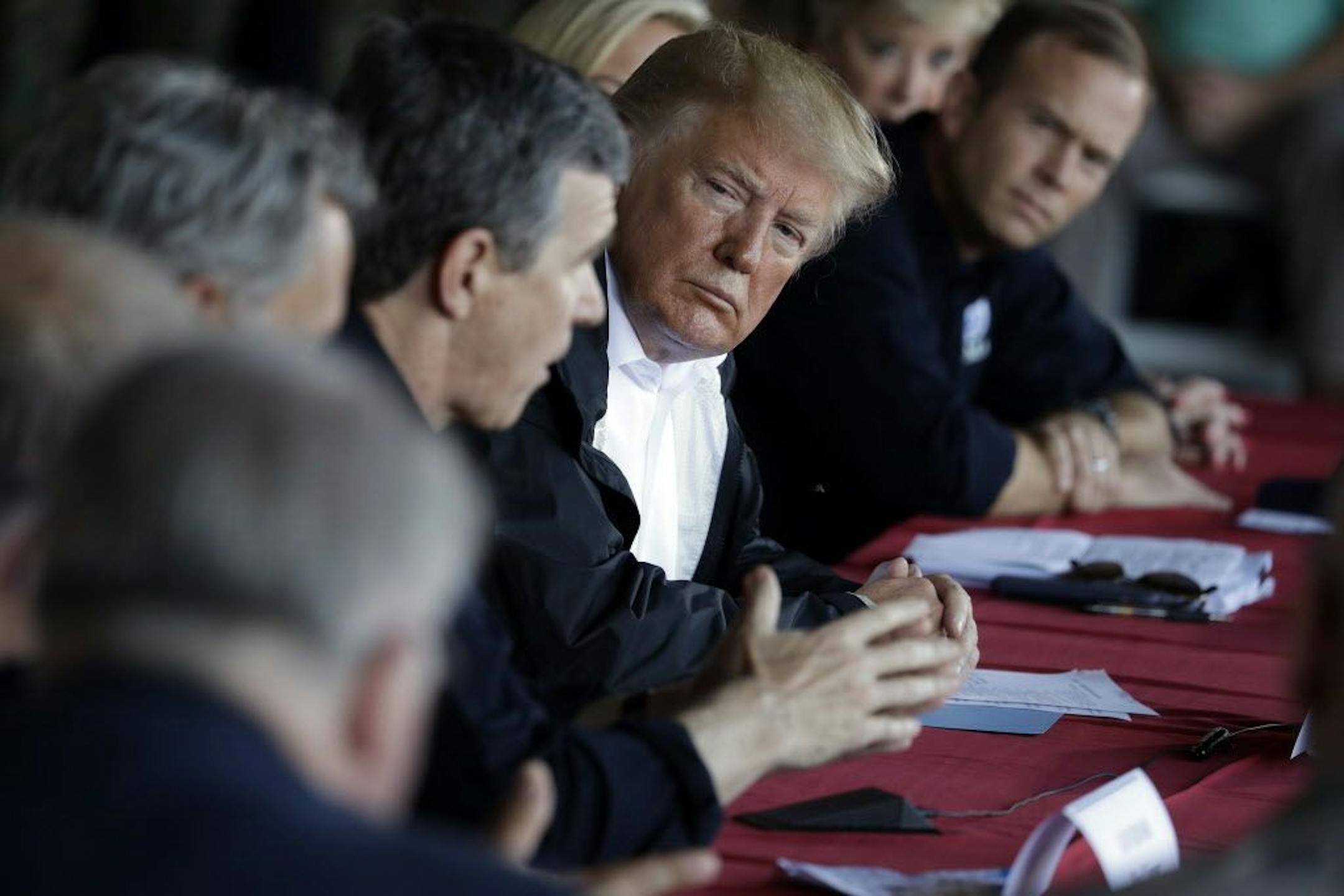 President Donald Trump listens as North Carolina Gov. Roy Cooper speaks while attending a briefing, after arriving at Marine Corps Air Station Cherry Point to visit areas impacted by Hurricane Florence, Wednesday, Sept. 19, 2018, in Havelock, N.C. FEMA Administrator Brock Long is leaning in a right.