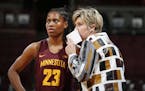 Minnesota head coach Marlene Stollings confers with guard Kenisha Bell