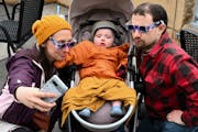 Bridget and Adam Gerenz, of St. Paul, take a sad selfie with their 10-month old son, Liam, after trying to get a view of the eclipse through the cloud