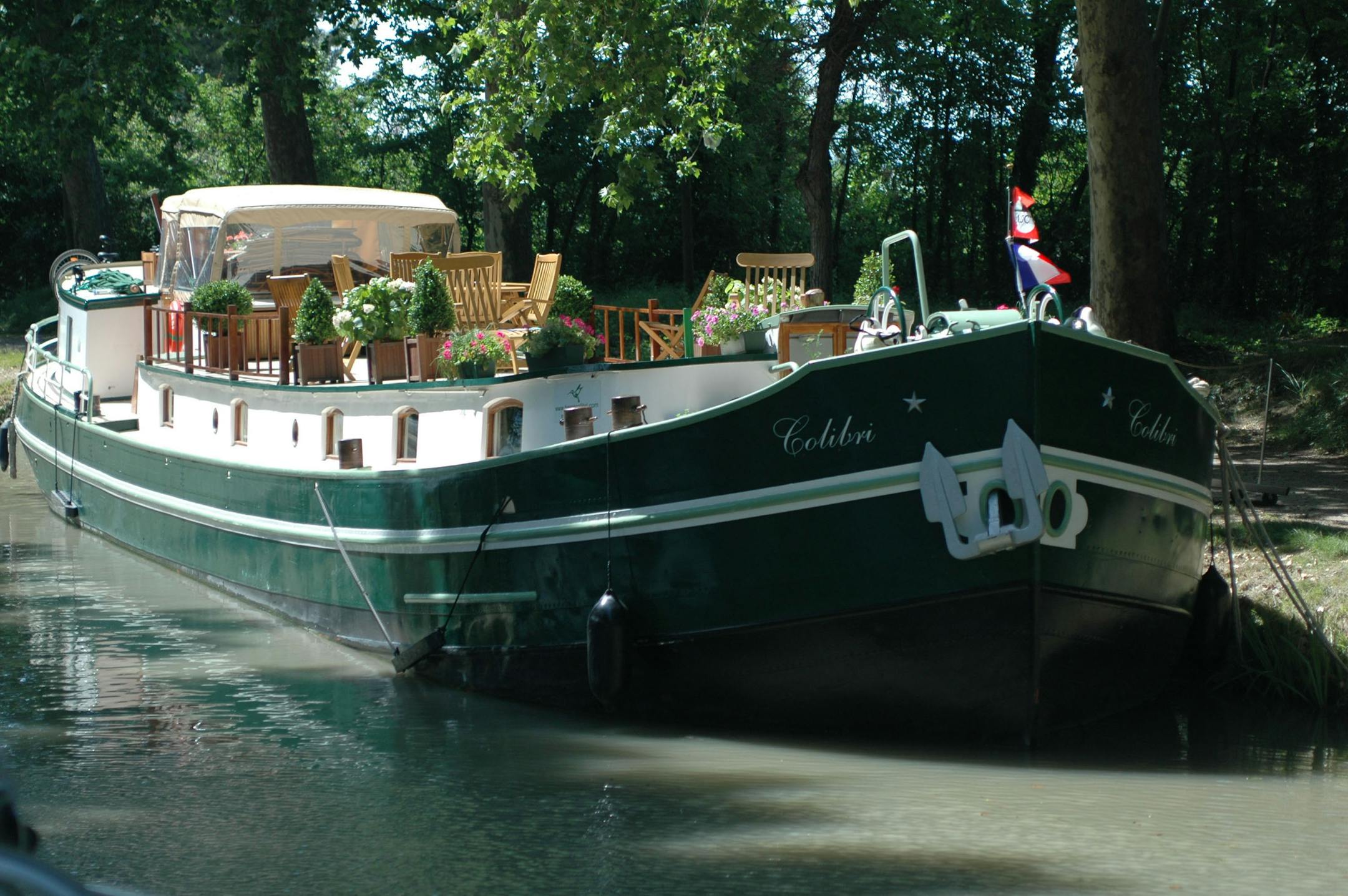 A river boats sits docked on a canal in the South of France.