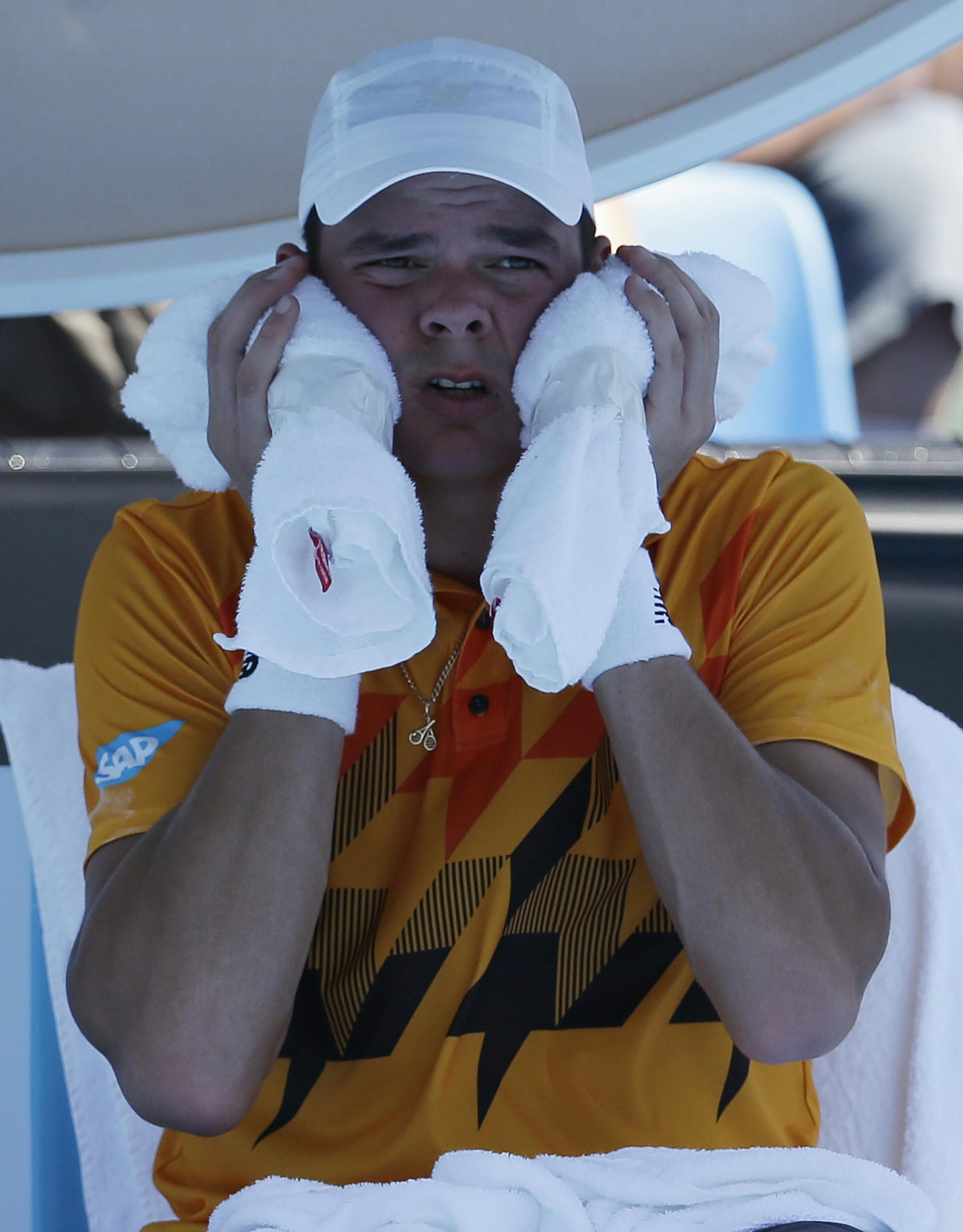 Milos Raonic of Canada cools himself with an ice pack during a break in his first round match against Daniel Gimeno-Traver of Spain at the Australian Open tennis championship in Melbourne, Australia, Tuesday, Jan. 14, 2014. (AP Photo/Aijaz Rahi)