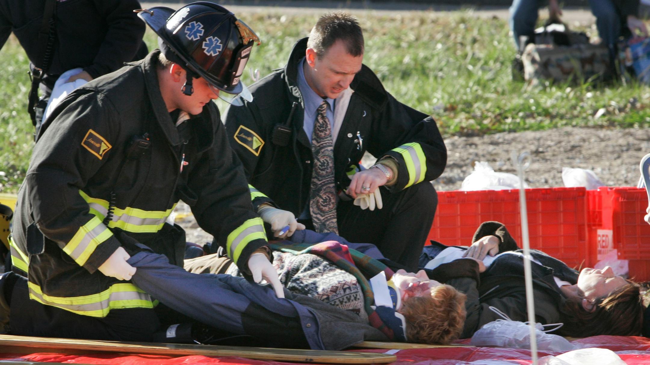 Two passengers who were onboard an Amtrak passenger train that plowed into the back of a freight train on Chicago's South Side are treated at the scene, Friday, Nov. 30, 2007. (AP Photo/Charles Rex Arbogast)