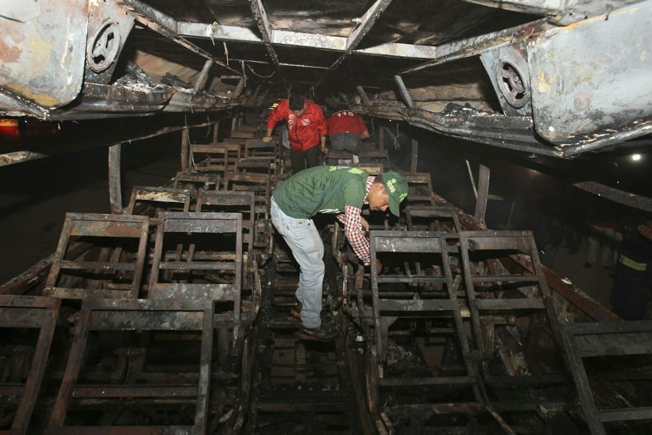 Pakistani rescue workers search through the wreckage of a passenger bus destroyed after colliding with an oil tanker on a highway near Karachi, Pakistan, early Sunday, Jan. 11, 2015. Dozens of people were killed in the accident.