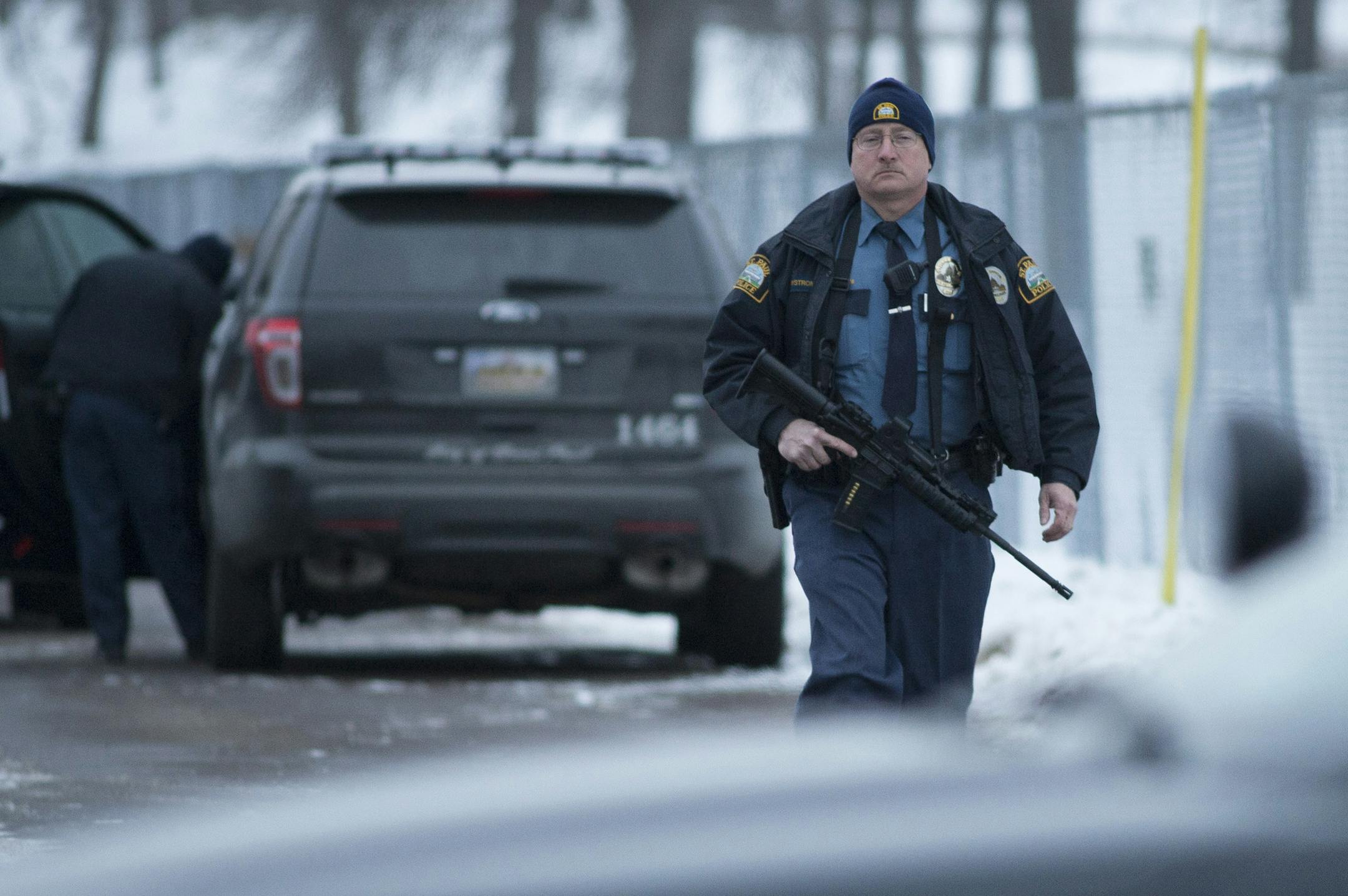 A St. Paul police officer returns to his car at the West Sycamore Street and Sylvan Street intersection in St. Paul after the end of a standoff Friday. ] (Aaron Lavinsky | StarTribune) ORG XMIT: MIN1501021653180205