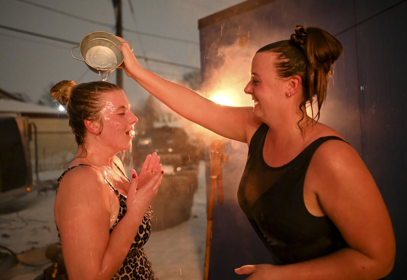 Hannah Peine, of St .Paul, poured water onto the head of her friend, Lindsey Hostetler, of Northfield, after they emerged from a sauna Thursday night. ] Aaron Lavinsky &#x2022; aaron.lavinsky@startribune.com Minnesotan's latest attempt to thumb their noses at winter is a sauna village in Tangletown. We photograph the Sauna Village in on Wednesday, Jan. 22, 2020 in Minneapolis, Minn.