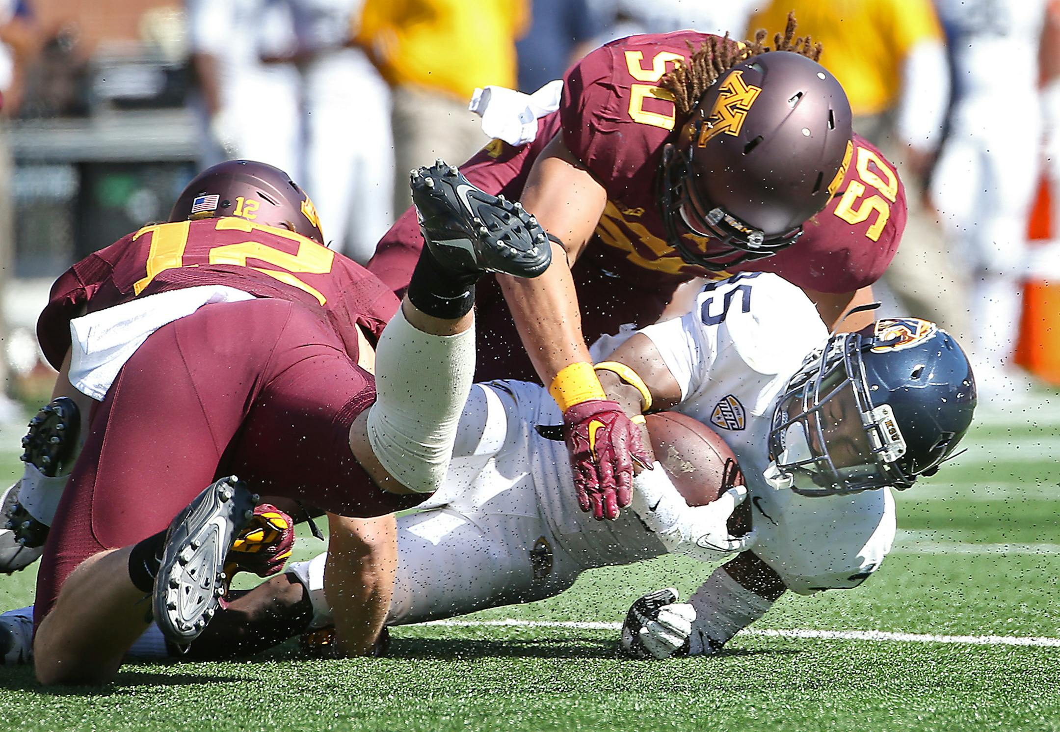 Minnesota linebackers Cody Poock, left, Jack Lynn stopped Kent State wide receiver Ernest Calhoun.
