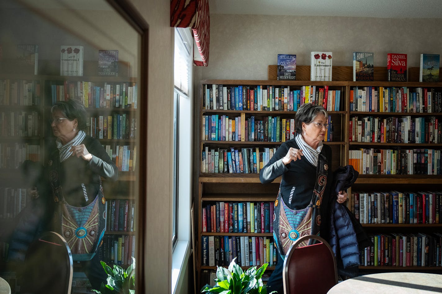 Nancy Brand, vice president of the HOA at Windwood Condominiums, gives a tour of the library and card room.