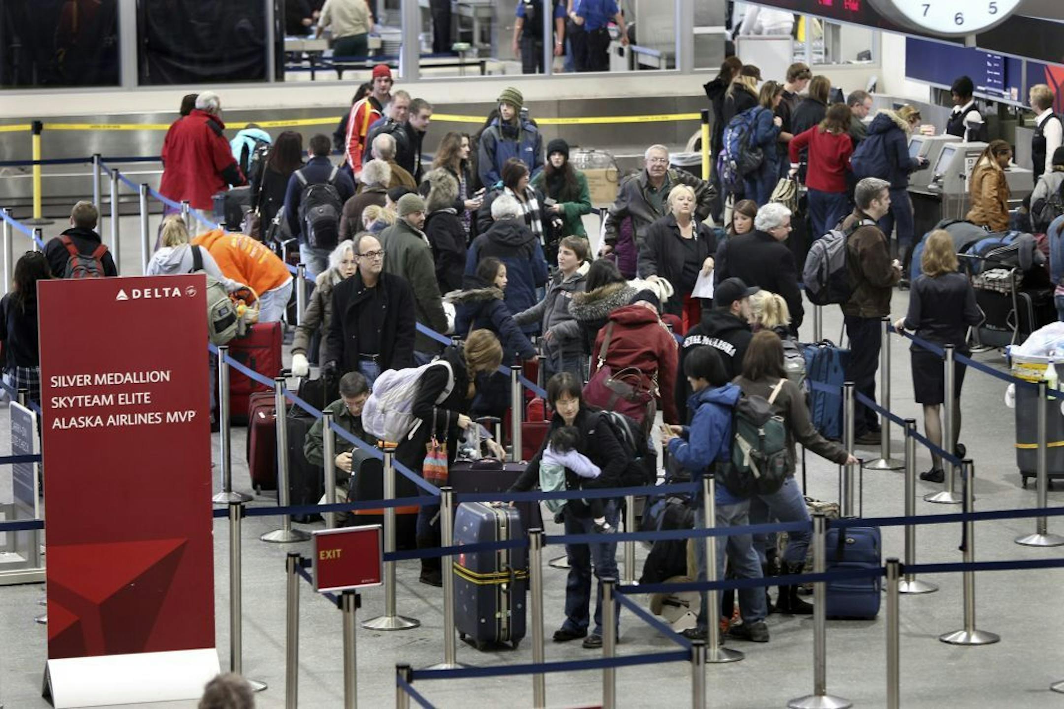 Travelers waited in a ticket line at the Delta Airlines counter.