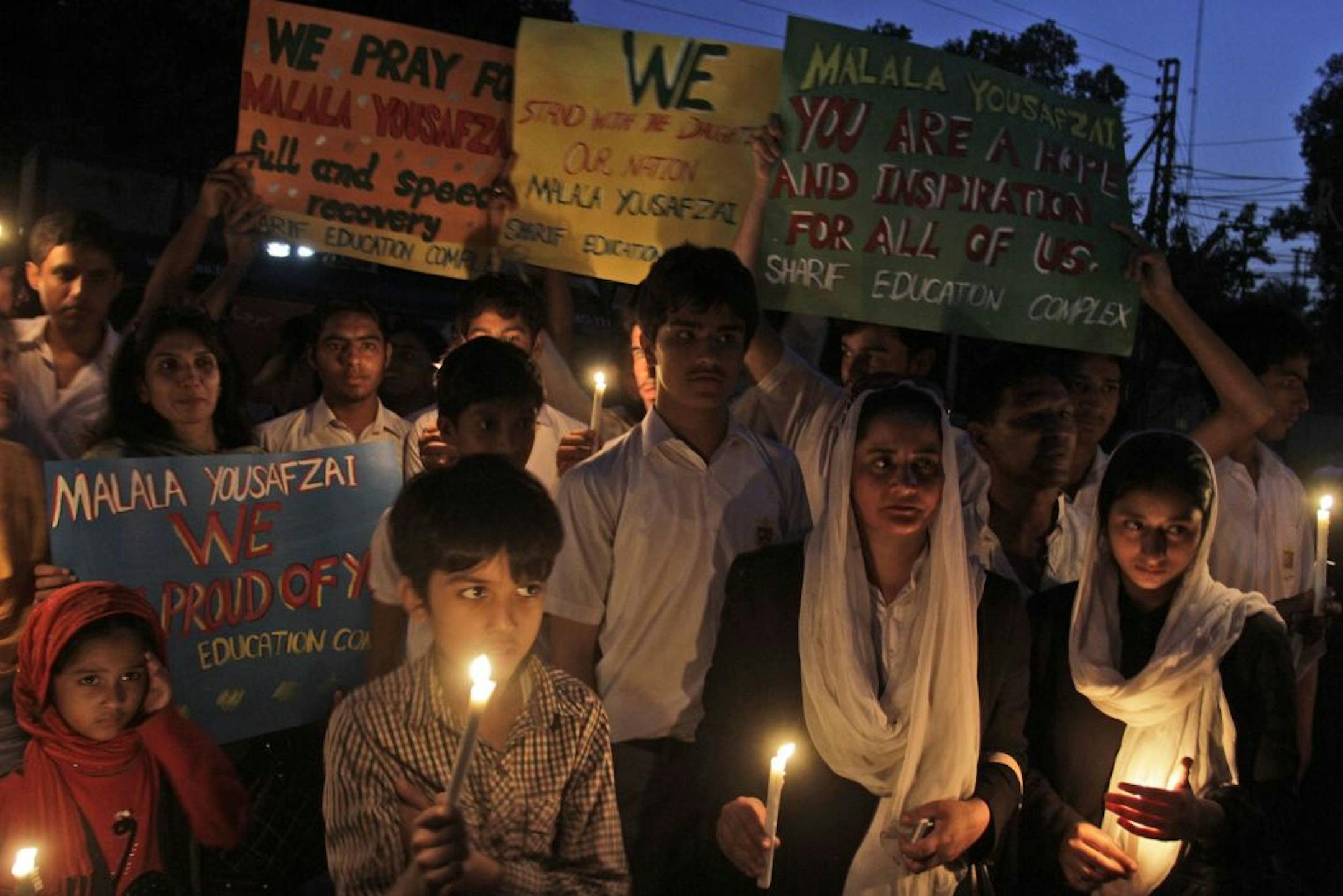 Pakistani children and adults, hold candles and banners, during a protest condemning the attack on schoolgirl Malala Yousufzai, in Lahore, Pakistan, Wednesday, Oct. 10, 2012. Pakistani doctors successfully removed a bullet Wednesday from the neck of a 14-year-old girl who was shot by the Taliban for speaking out in support of education for women, a government minister said.
