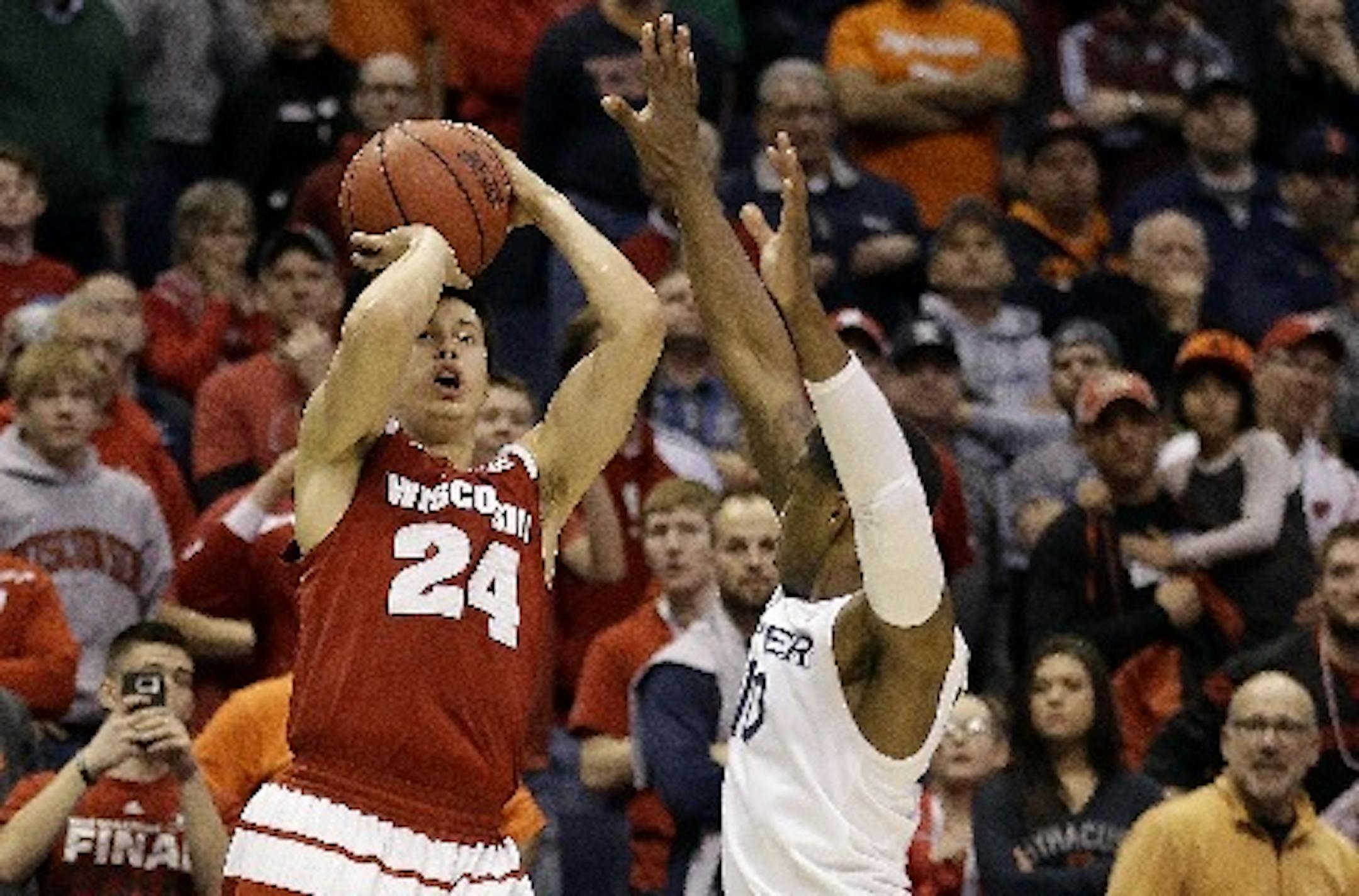 Wisconsin's Bronson Koenig, left, hit a last-second three-point shot over Xavier's Remy Abell to give Wisconsin a 66-63 victory in a second-round game in the NCAA tournament Sunday in St. Louis.