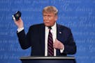 FILE - In this Sept. 29, 2020, file photo, President Donald Trump holds up his face mask during the first presidential debate at Case Western Universi