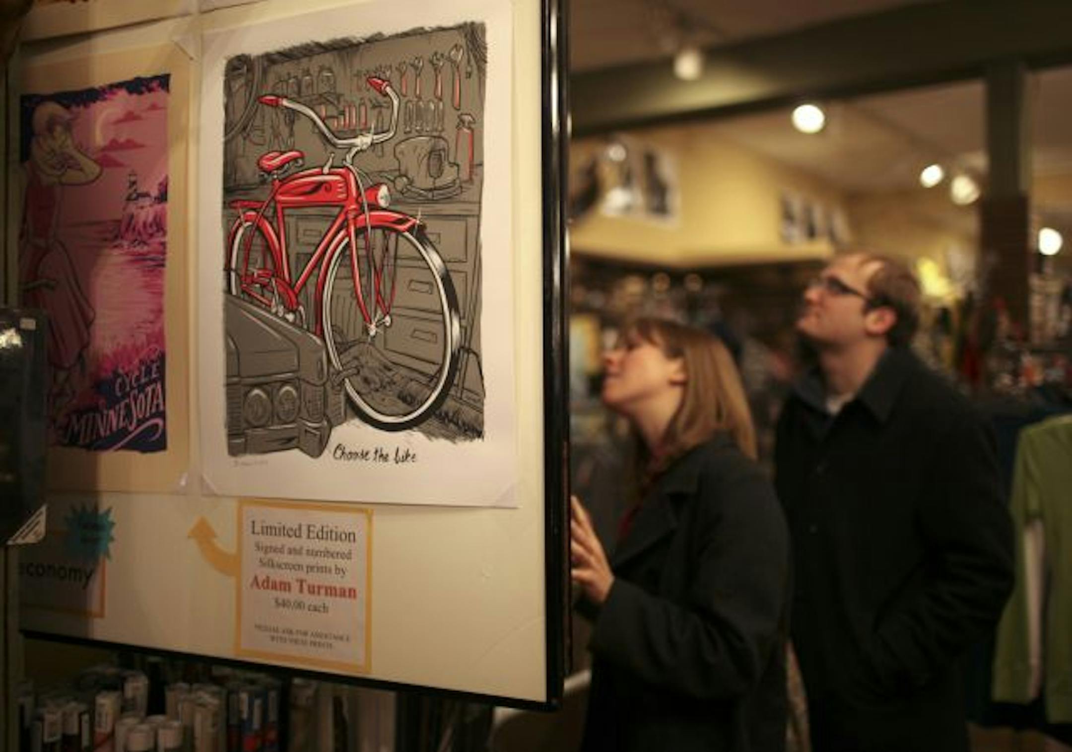 Christina Giunta and Zak Schneider browsed at a poster display that featured silkscreen artist Adam Turman. Turman is the first artist to be featured in the Electric Fetus' MinnEconomy campaign, which kicked off Thursday night.