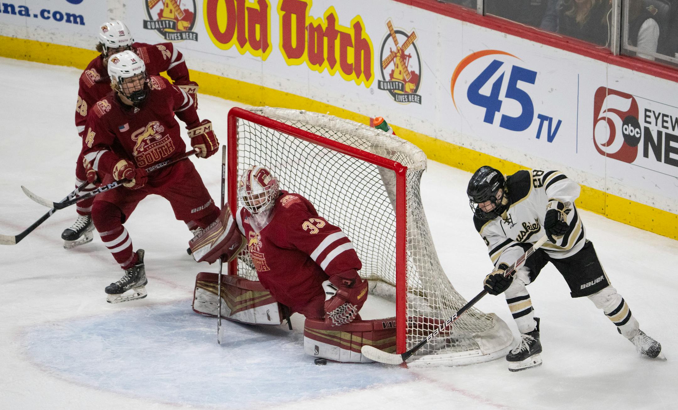 Lakeville South Cougars goaltender Jack Hochsprung (33) stopped a wraparound attempt by Andover Huskies forward Luke Babineau (28) in the second period.