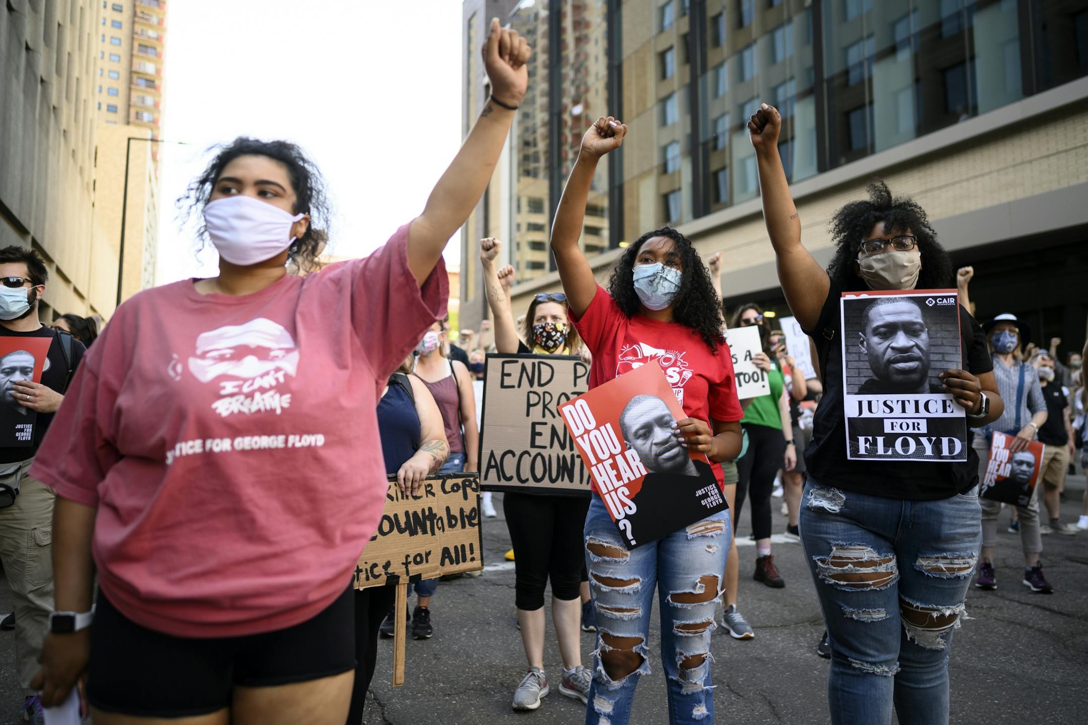 From left, Sherie Jones, Jaelah (no last name given) and Destiny Franks, all from Minneapolis, raised their fists in the air during Friday night's protest outside Minnesota Attorney General Keith Ellison's downtown St. Paul office.