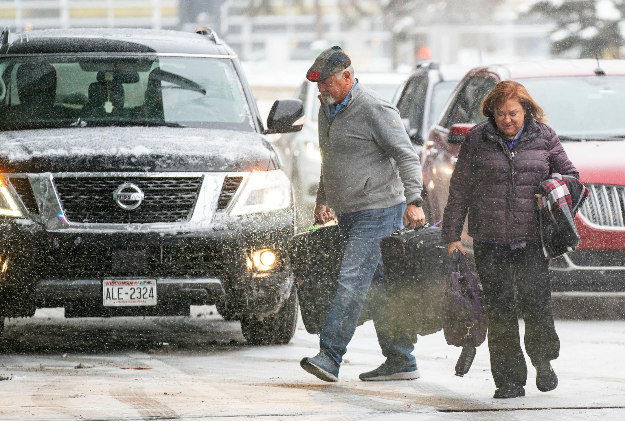 Travelers walk through the snow into Terminal 1 at Minneapolis-Saint Paul International Airport.