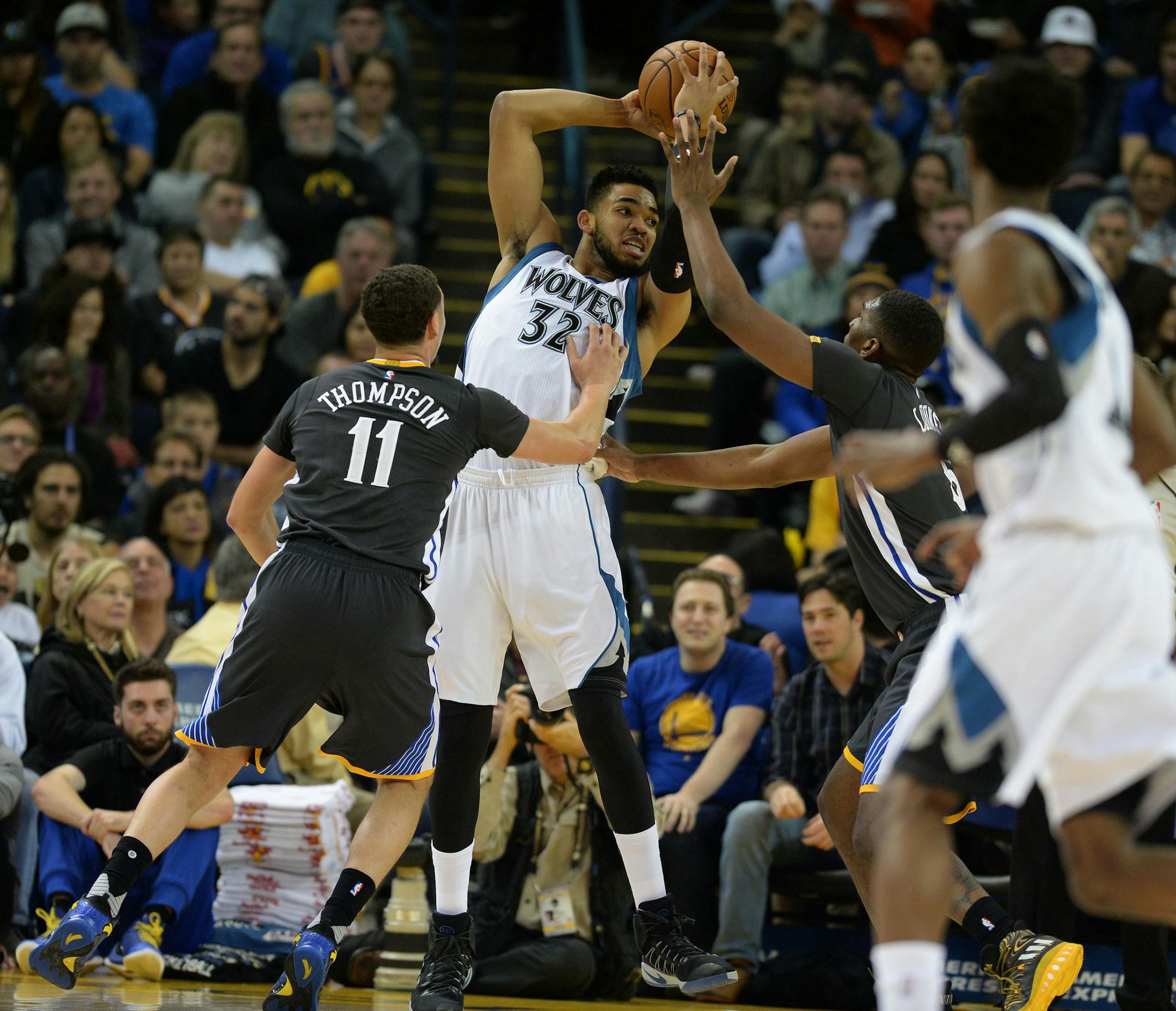 The Golden State Warriors' Klay Thompson (11) and Kevon Looney (5) pressure the Minnesota Timberwolves' Karl-Anthony Towns (32) in the first half at Oracle Arena in Oakland, Calif., on Saturday, Nov. 26, 2016. (Dan Honda/Bay Area News Group/TNS) ORG XMIT: 1193732
