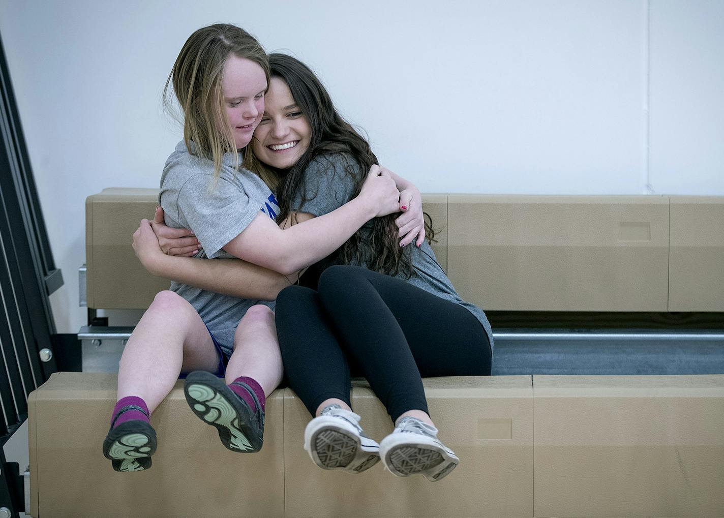 Wayzata junior Brenna Kyle, right, got a hug from Megan Sturman, left, as they waited for Unified PE to begin at Wayzata High School, Thursday, January 18, 2018 in Plymouth, MN. Wayzata is in its second year of a wildly successful program called Unified PE, which brings together general students with special needs students in the same physical education class. It's so popular that the class fills up fast and they've developed a Unified club program after school. ] ELIZABETH FLORES &#xef; liz.flo