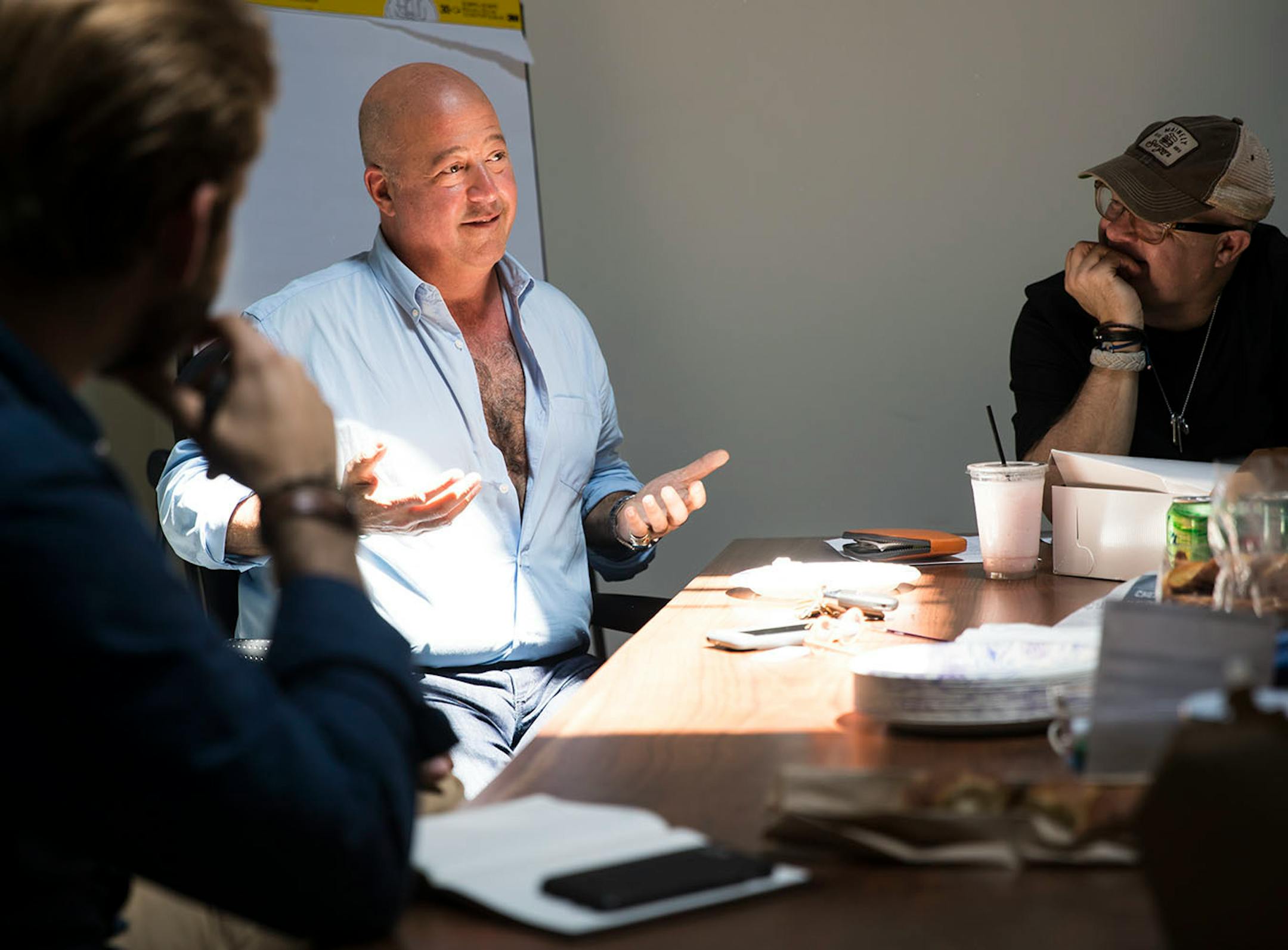 Andrew ZImmern's unbuttoned his shirt as he was trying to be funny while doing an impression of someone during a meeting at his office in St. Louis Park, Minn., on Friday, May 26, 2017. At left is Stiles Anderson, a consultant and advisor to Andrew, and at right is Tom Weiss, Andrew's lawyer.