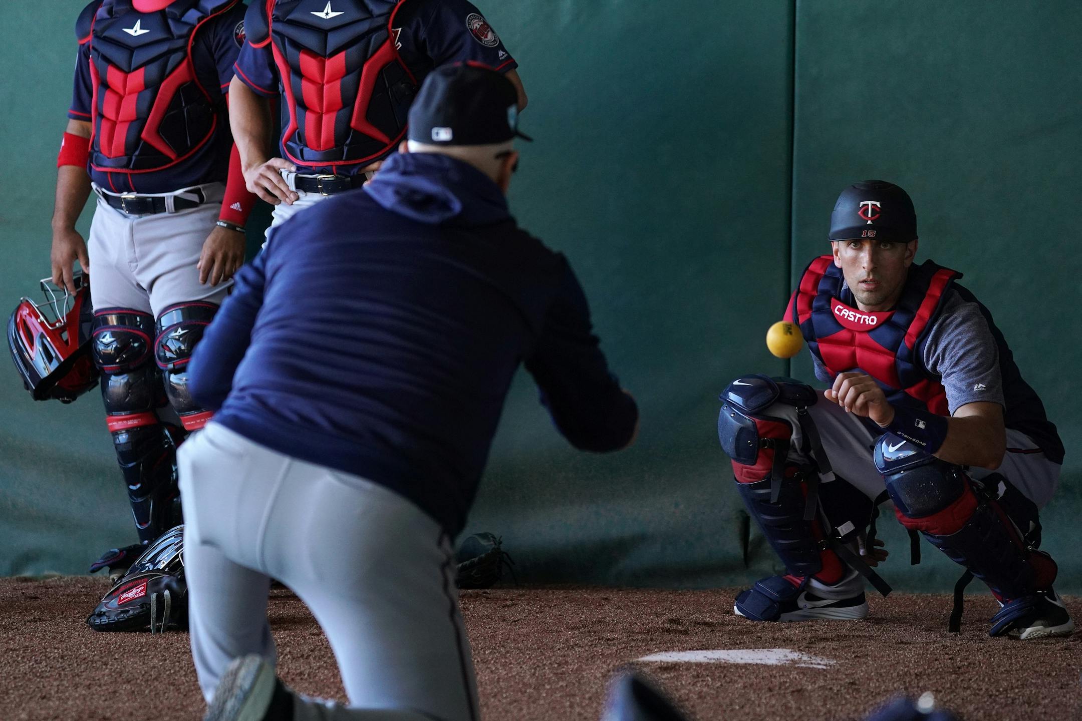 Major league coach Bill Evers worked with catcher Jason Castro (15) in the bullpen Thursday morning.