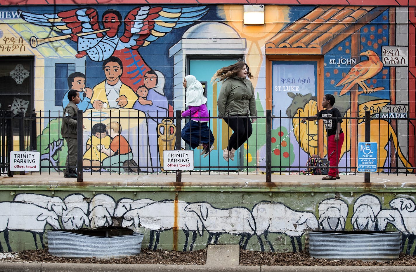 Anwar Yahya, 11, Ismahaan Issack, 10, Mellisa Huesman, 21, and Said Yahya, 9, took turns jumping rope at Trinity Lutheran in Minneapolis.