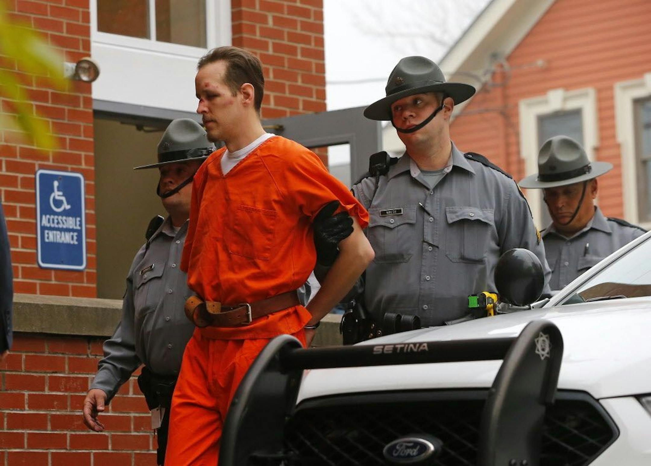 Eric Frein is escorted by police into the Pike County Courthouse for his arraignment in Milford, Pa., Friday Oct. 31, 2014.