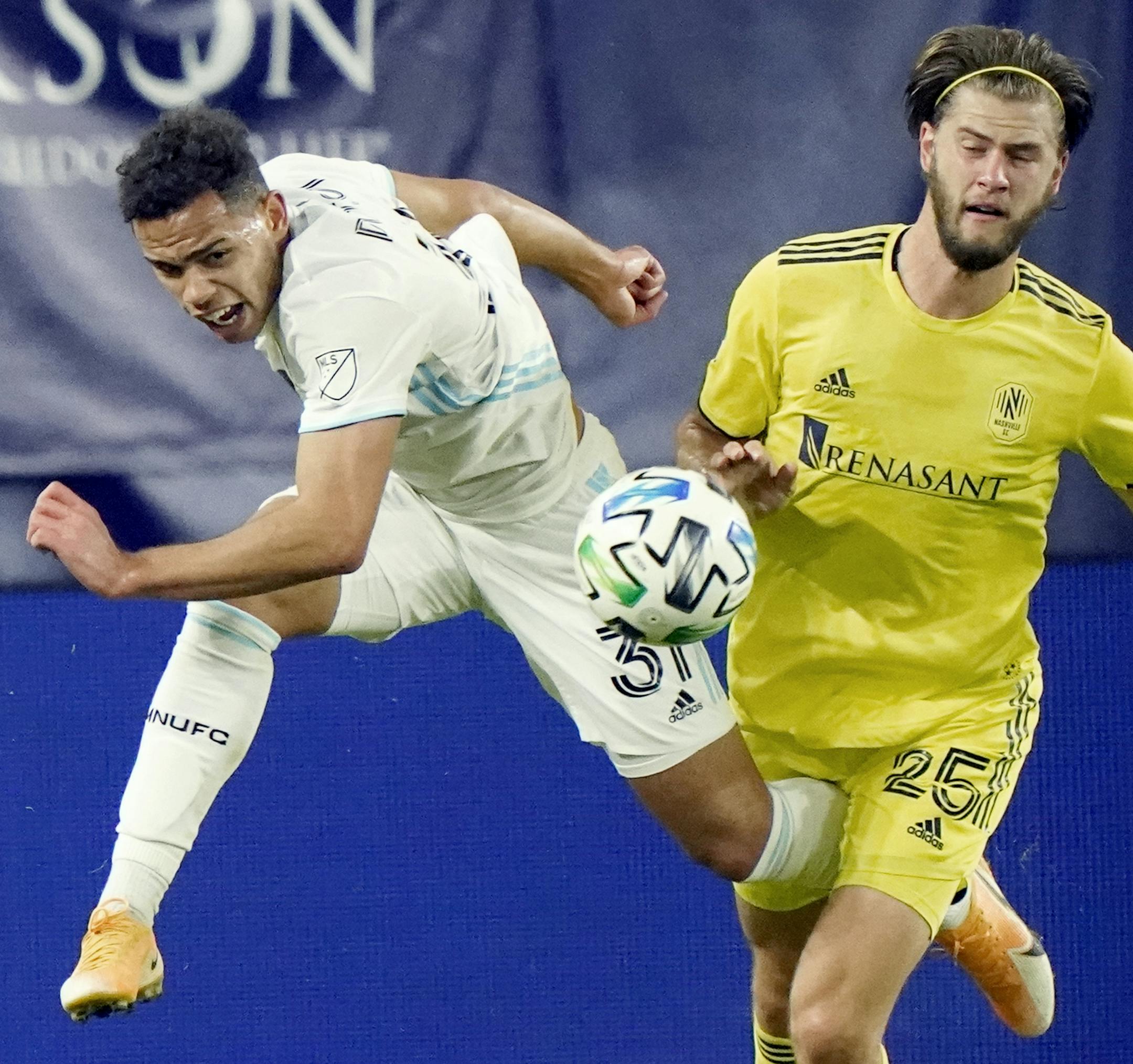 Minnesota United midfielder Hassani Dotson (31) and Nashville defender Walker Zimmerman (25) chase down the ball during the second half of an MLS soccer match Tuesday, Oct. 6, 2020, in Nashville, Tenn. (AP Photo/Mark Humphrey)