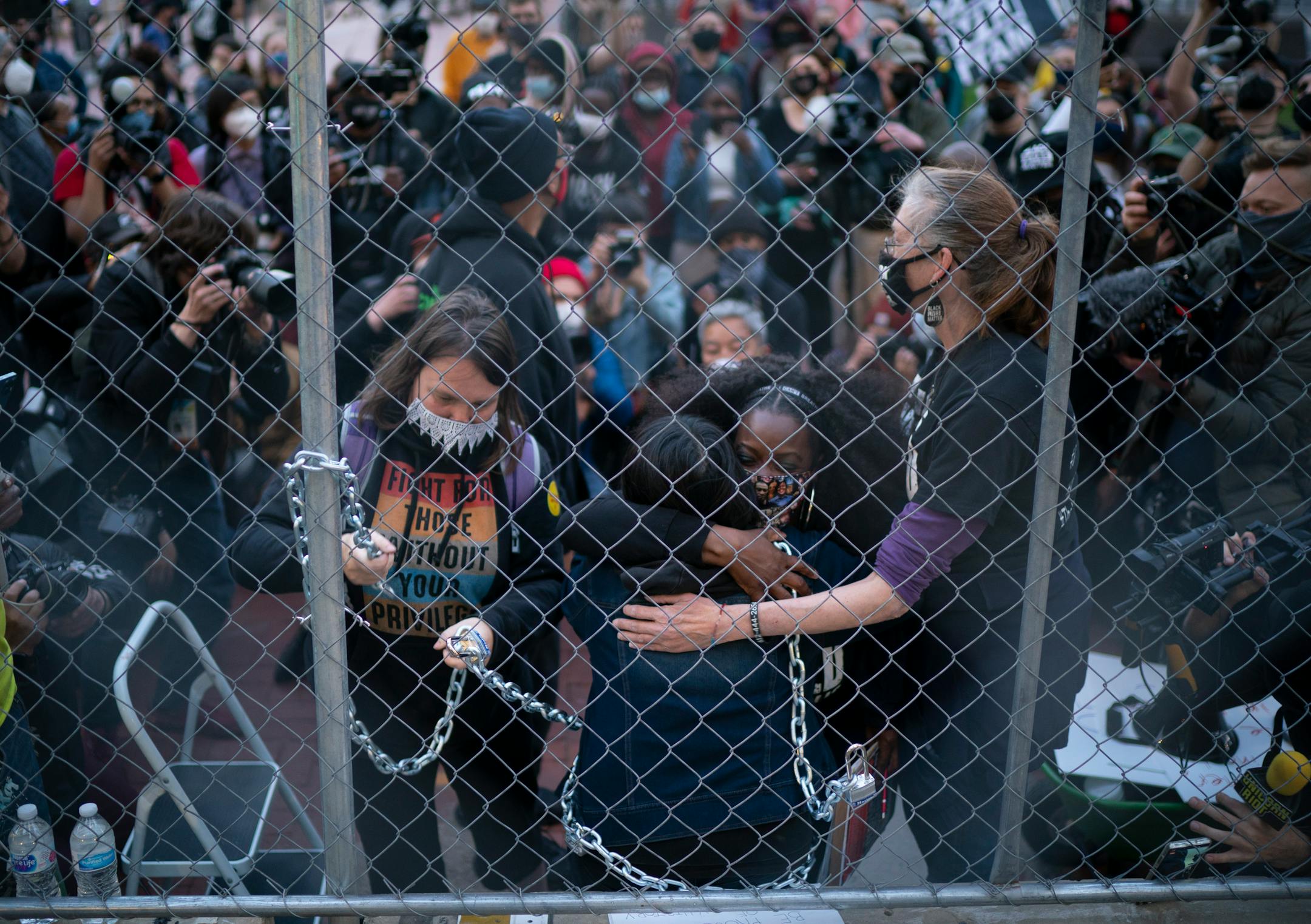 Activist Maya Hart received hugs for support as she had herself chained to the fence surrounding the Hennepin County Government Center.