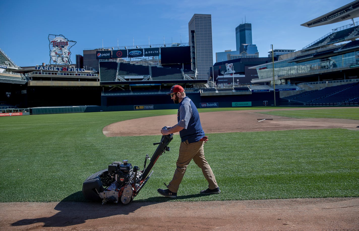 Ian Almquist, with the Twins grounds crew, mowed the lawn at Target Field on Friday. The Twins open the season from March 26-April 1 in Oakland and Seattle, cities located in states that have, as of Tuesday, over 300 confirmed cases of coronavirus.