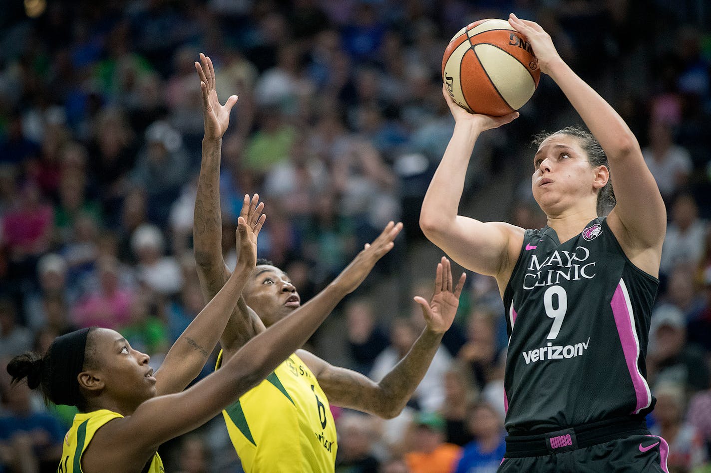 Seattle Storm guard Jewell Loyd, left, and forward Natasha Howard defended Minnesota Lynx forward Cecilia Zandalasini under the net during the third quarter.