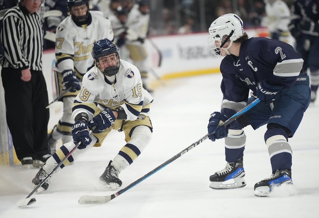 Chanhassen's Ryan McPartland (19) is defended by Rochester Century/John Marshall's Brody Jocelyn (2) in first Class 2A quarterfinal at the Xcel Energy Center. 
