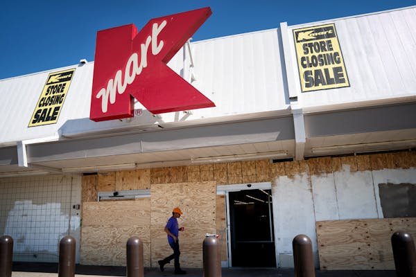 Employees took a break Wednesday from cleaning up damage from riots and looting at the Kmart store on E. Lake Street in Minneapolis. It will not reope