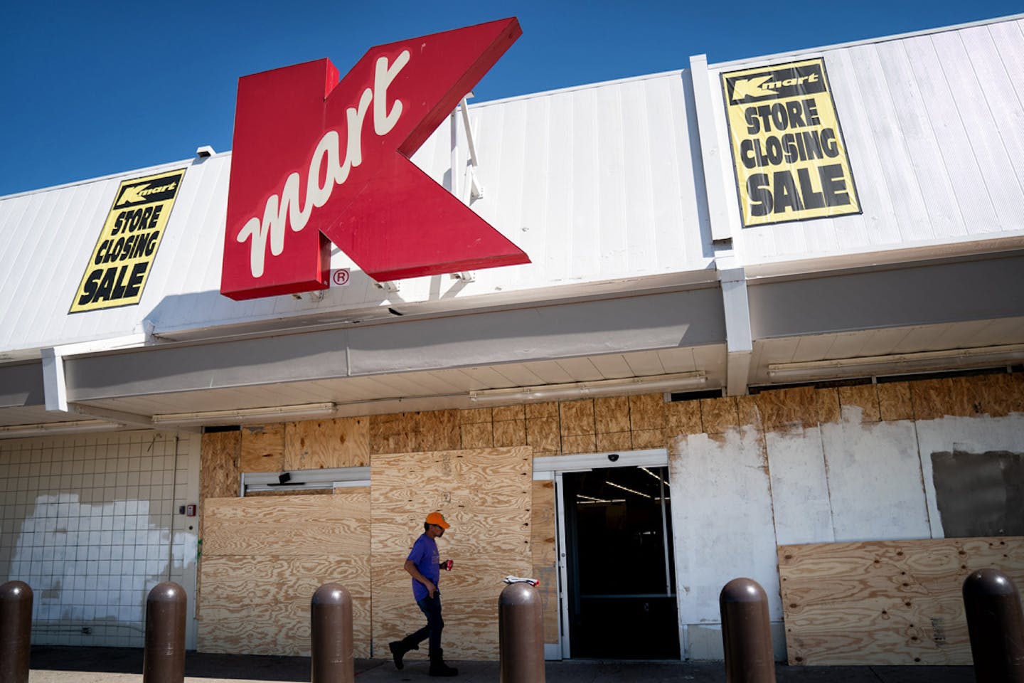 Employees took a break Wednesday from cleaning up damage from riots and looting at the Kmart store on E. Lake Street in Minneapolis. It will not reopen.