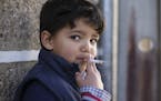 Fernando, 6-years-old, smokes a cigarette in the village of Vale de Salgueiro, northern Portugal, during the local Kings' Feast Saturday, Jan. 6, 2018