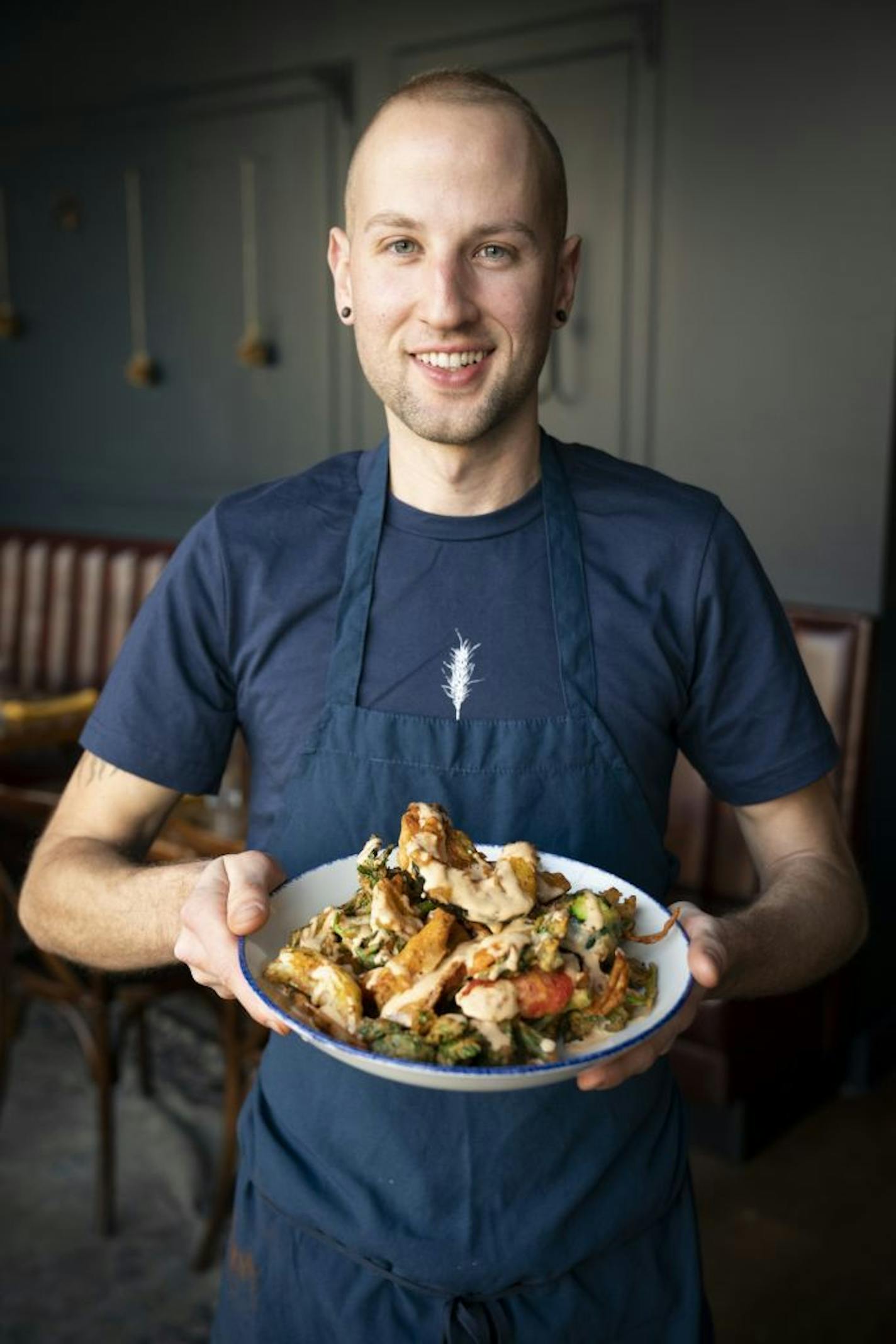 Fig and Farro general manager Joshua Hockstatter held bowl of the "Forgotten Foods" special made of deep fried tempura-battered vegetable scraps like carrot peels, celery leaves, sweet potato scraps and the ends of carrots, zucchinis, and red peppers, spiced with za'tar seasoning and drizzled with sriracha cashew crema in Minneapolis, Minn., on Thursday, January 31, 2019.