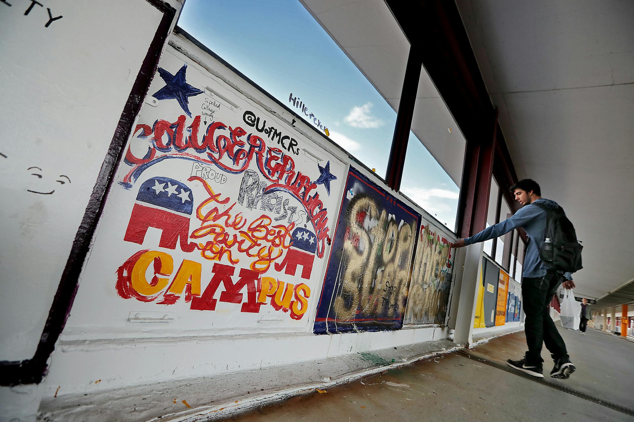 Dan Kreft, a senior psychology major at the University of Minnesota, showed a friend some graffiti that is rousing controversy over a &#x201c;build the wall&#x201d; message that university college Republicans painted on the Washington Avenue bridge, and others painted over, Tuesday, October 4, 2016 in Minneapolis.