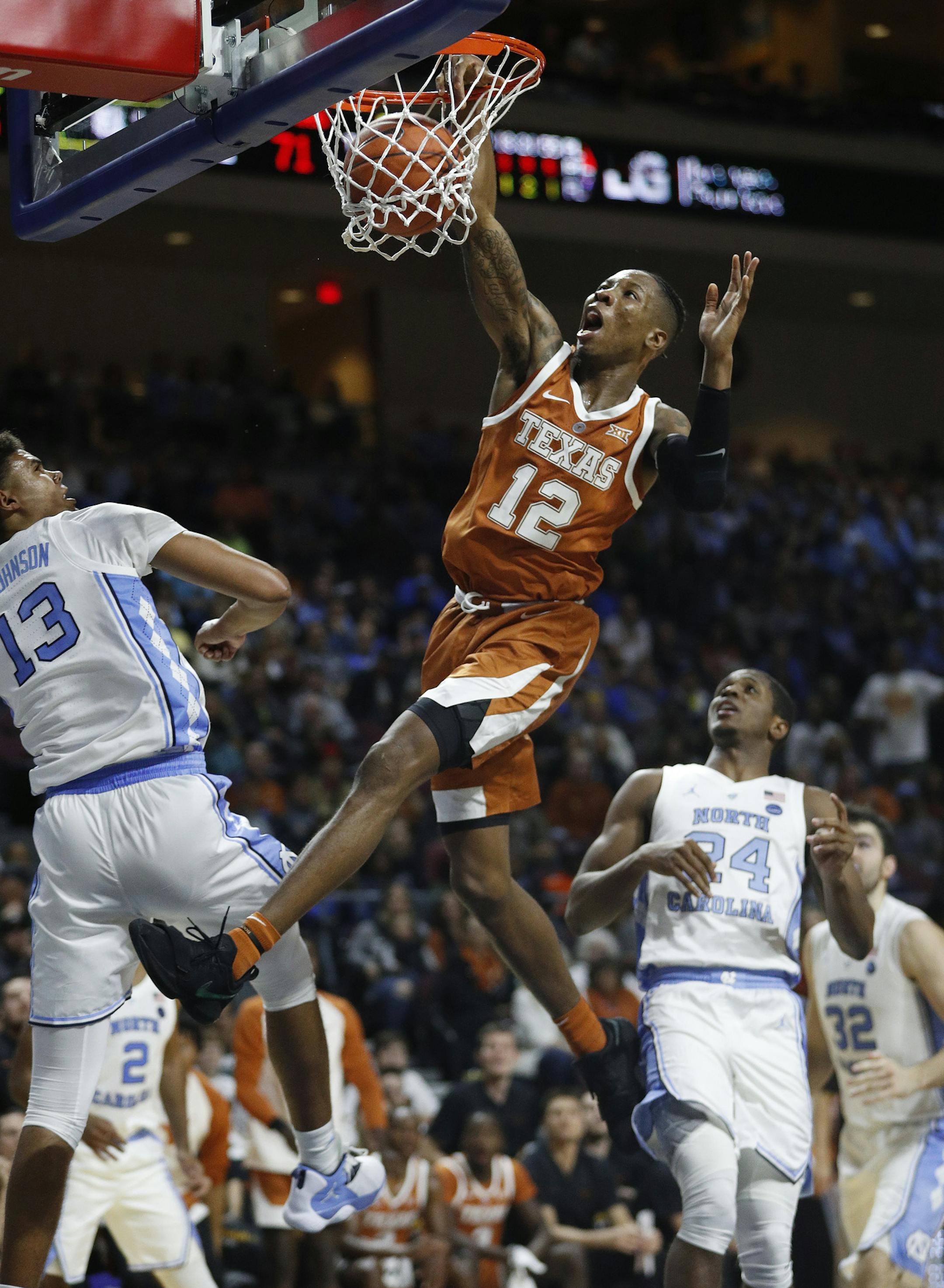 Texas' Kerwin Roach II (12) dunks against North Carolina's Cameron Johnson (13) during the second half of an NCAA college basketball game Thursday, Nov. 22, 2018, in Las Vegas. (AP Photo/John Locher)