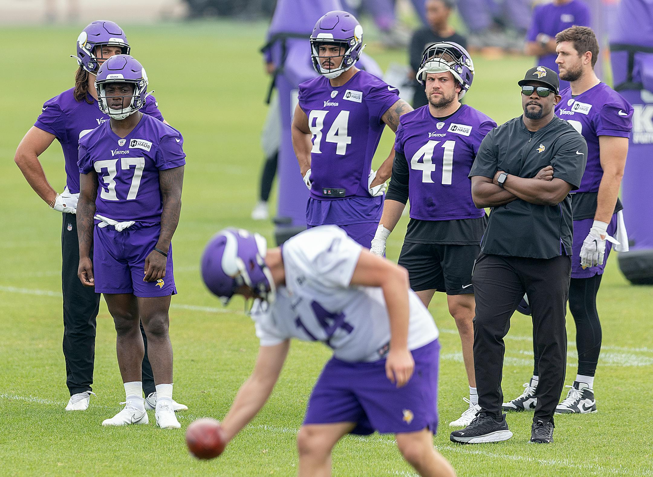 Vikings defensive coordinator Brian Flores, right, watches players run through drills during practice at the TCO Performance Center in Eagan, Minn., on Tuesday, June 6, 2023.