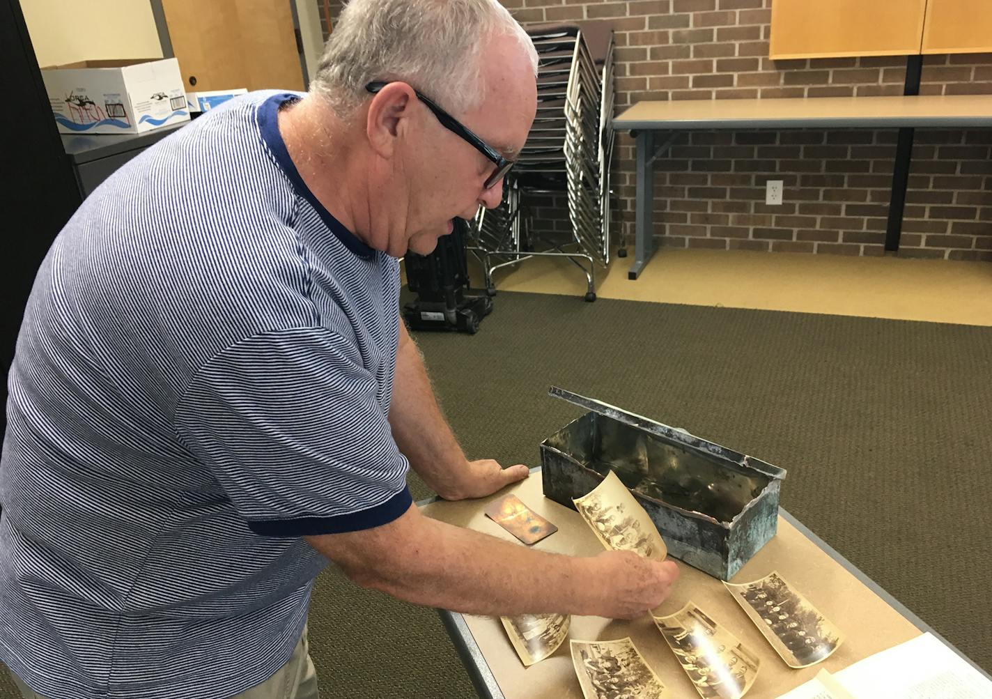 Beatrice Dupuy &#xef; beatrice.dupuy@startribune.com
Dennis Dvorak, founder of the New Prague Historical Society, holds up a photo of the girls&#xed; basketball team from 1923. Dvorak plans to put the New Prague High School time capsule on display at the New Prague Memorial Library in the fall.