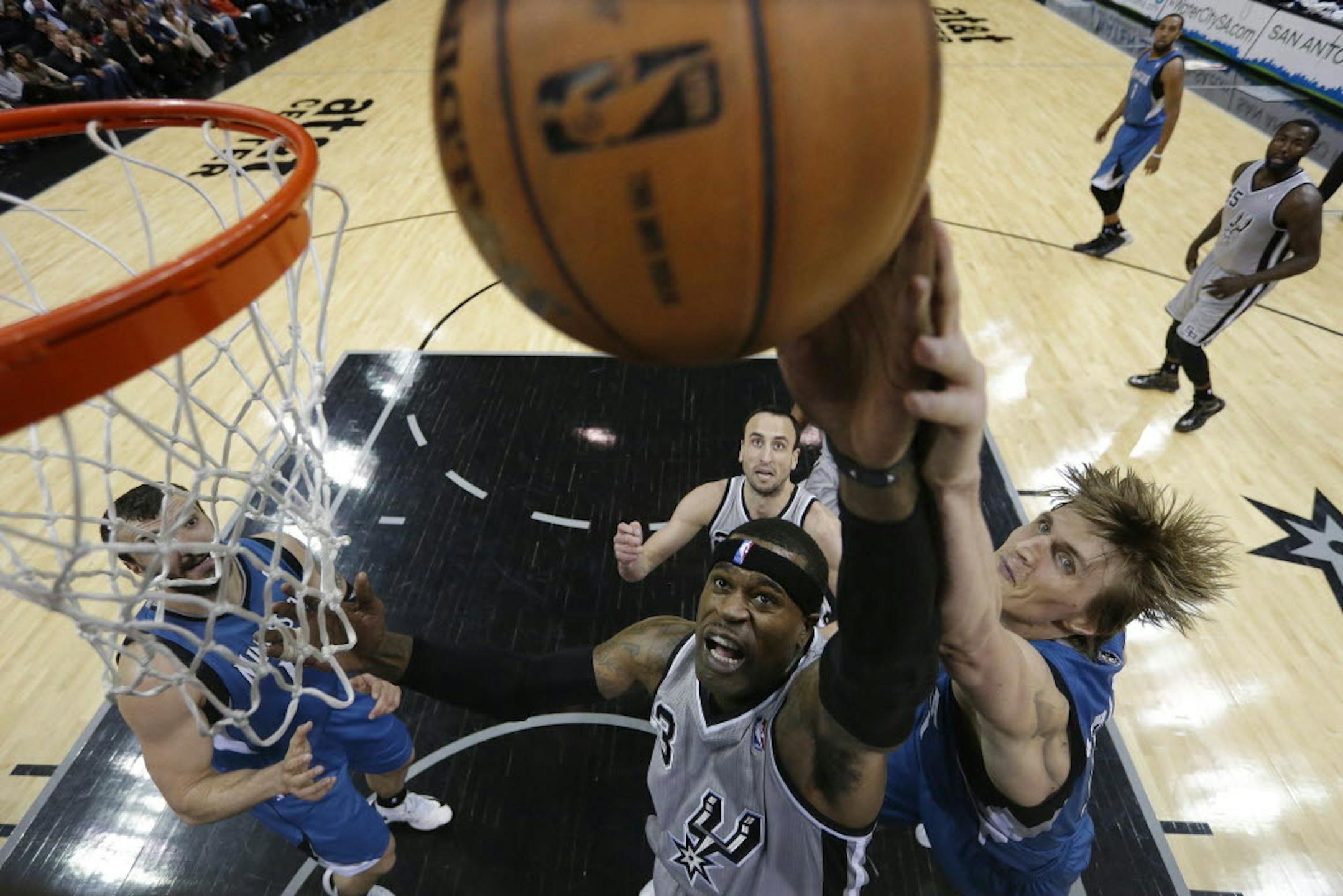 San Antonio's Stephen Jackson, front left, and Minnesota's Andrei Kirilenko reach for a rebound.