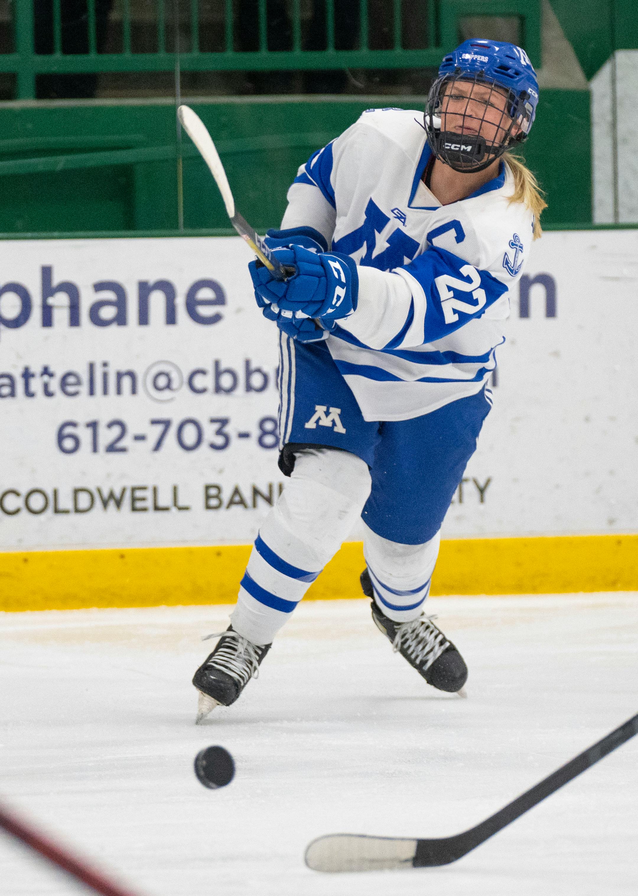 Minnetonka defender Elly Klepinger (22) takes a shot against Holy Family during the first period.