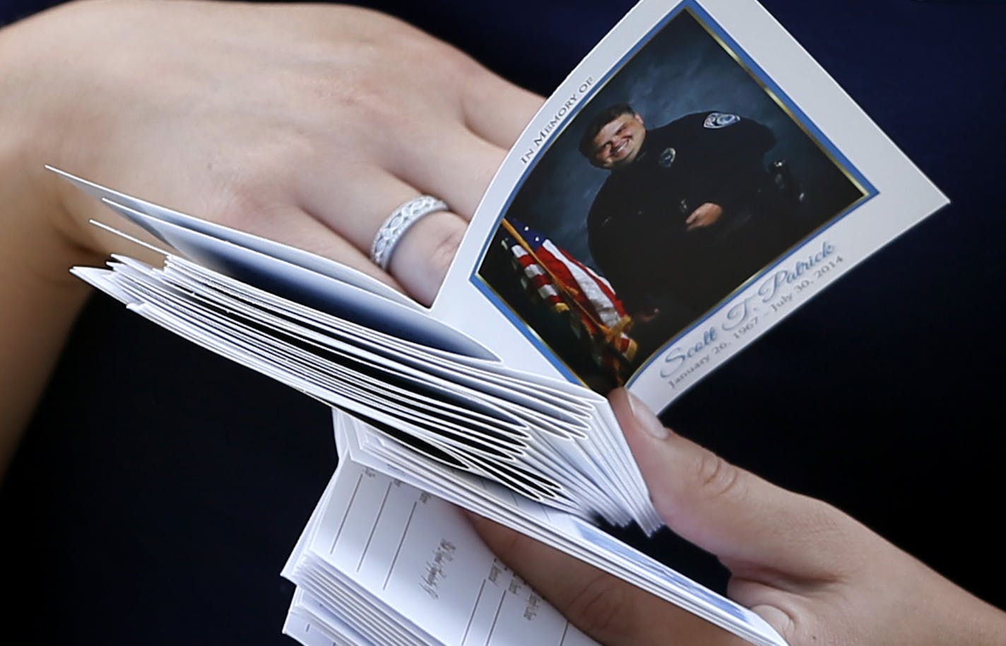 A women passed out programs during visitation for slain Mendota Heights police officer Scott Patrick at St. Stephen's Lutheran Church Tuesday August 5 , 2014 in West St. Paul , MN . .] Jerry Holt Jerry.holt@startribune.com